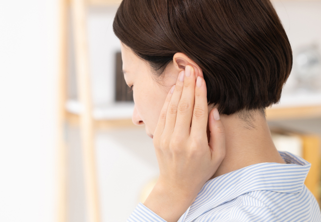 女性が耳を抑えているイメージ